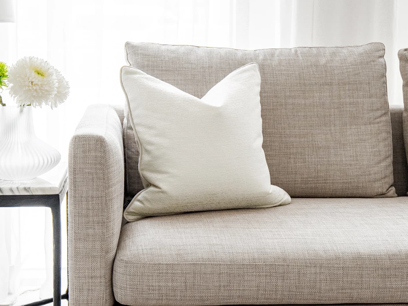 Divina Bianca single cushions in white, shown in a lifestyle front view