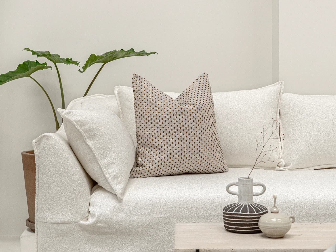 Dotty Rust single cushions in rust and beige, shown in a lifestyle front view