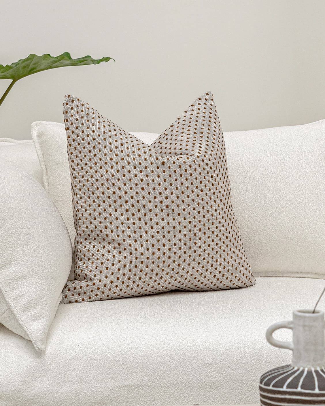 Dotty Rust cushion in beige, shown in a lifestyle front view as image 2