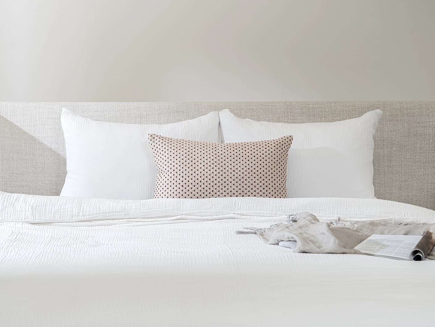 Dotty Rust III single cushions in rust, beige and grey, shown in a lifestyle front view