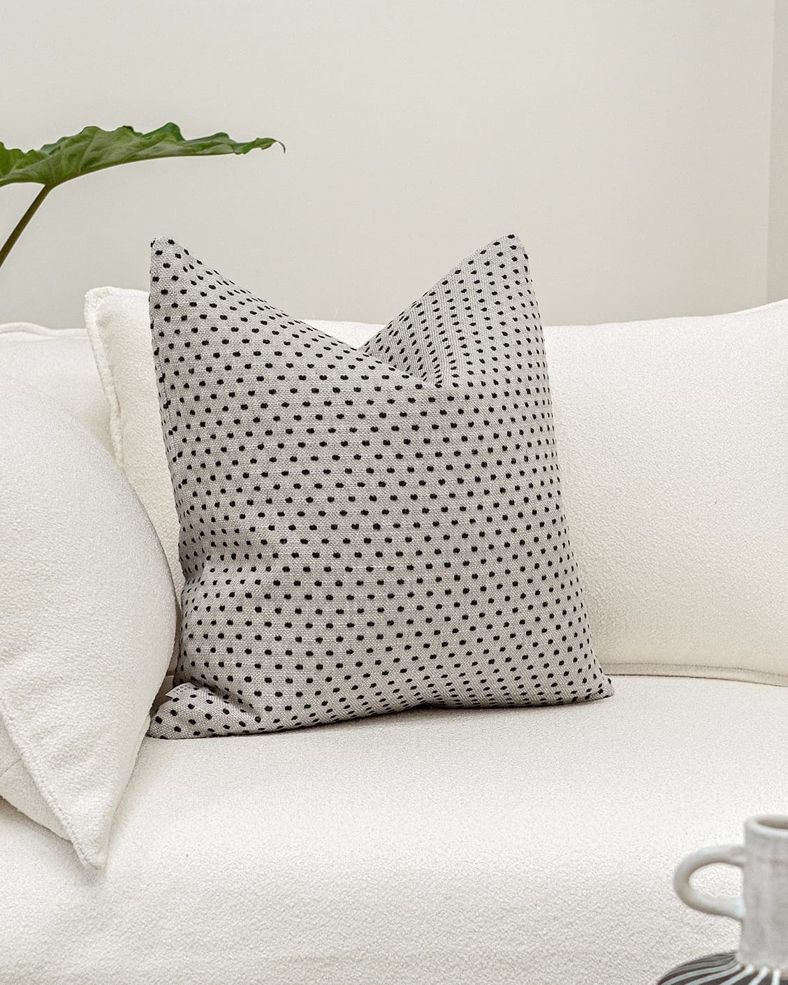 Dotty Steele cushion in grey, shown in a lifestyle front view as image 2