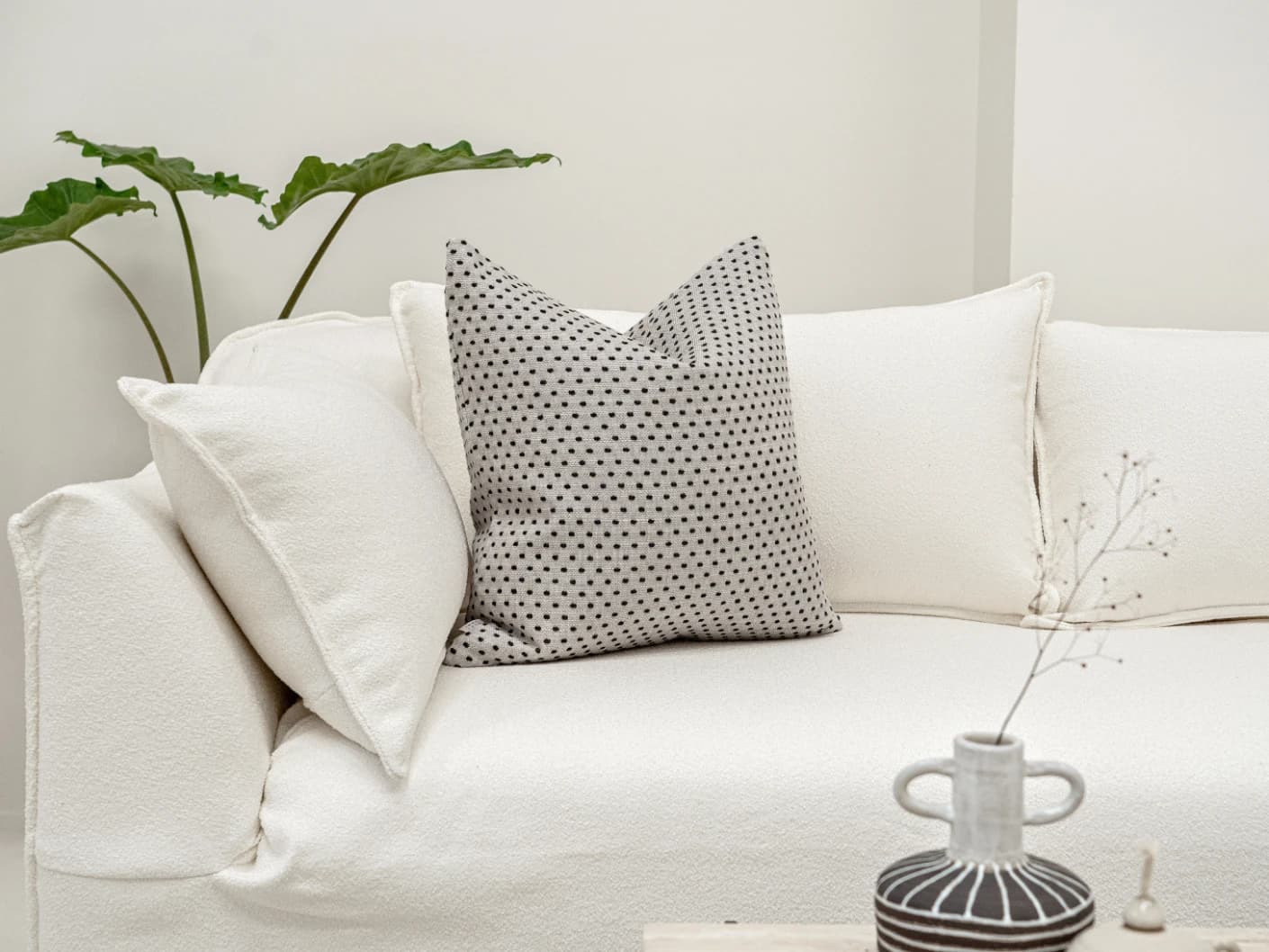 Dotty Steele single cushions in grey, shown in a lifestyle front view