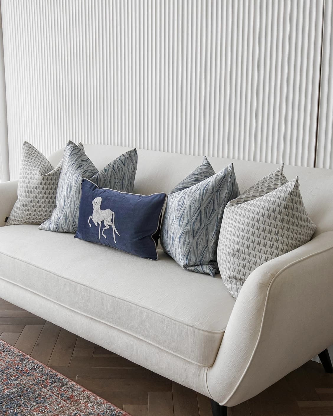Edwin Bundle cushion in blue, silver and white, shown in a lifestyle right view as image 2
