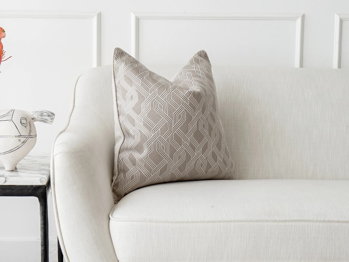 Elena Bianca single cushions in beige and white, shown in a lifestyle front view