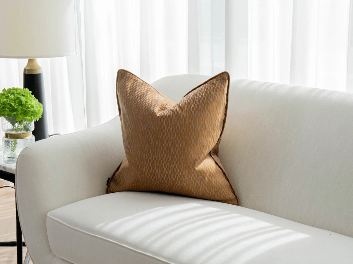 Elodie Hodler single cushions in silver and orange, shown in a lifestyle front view