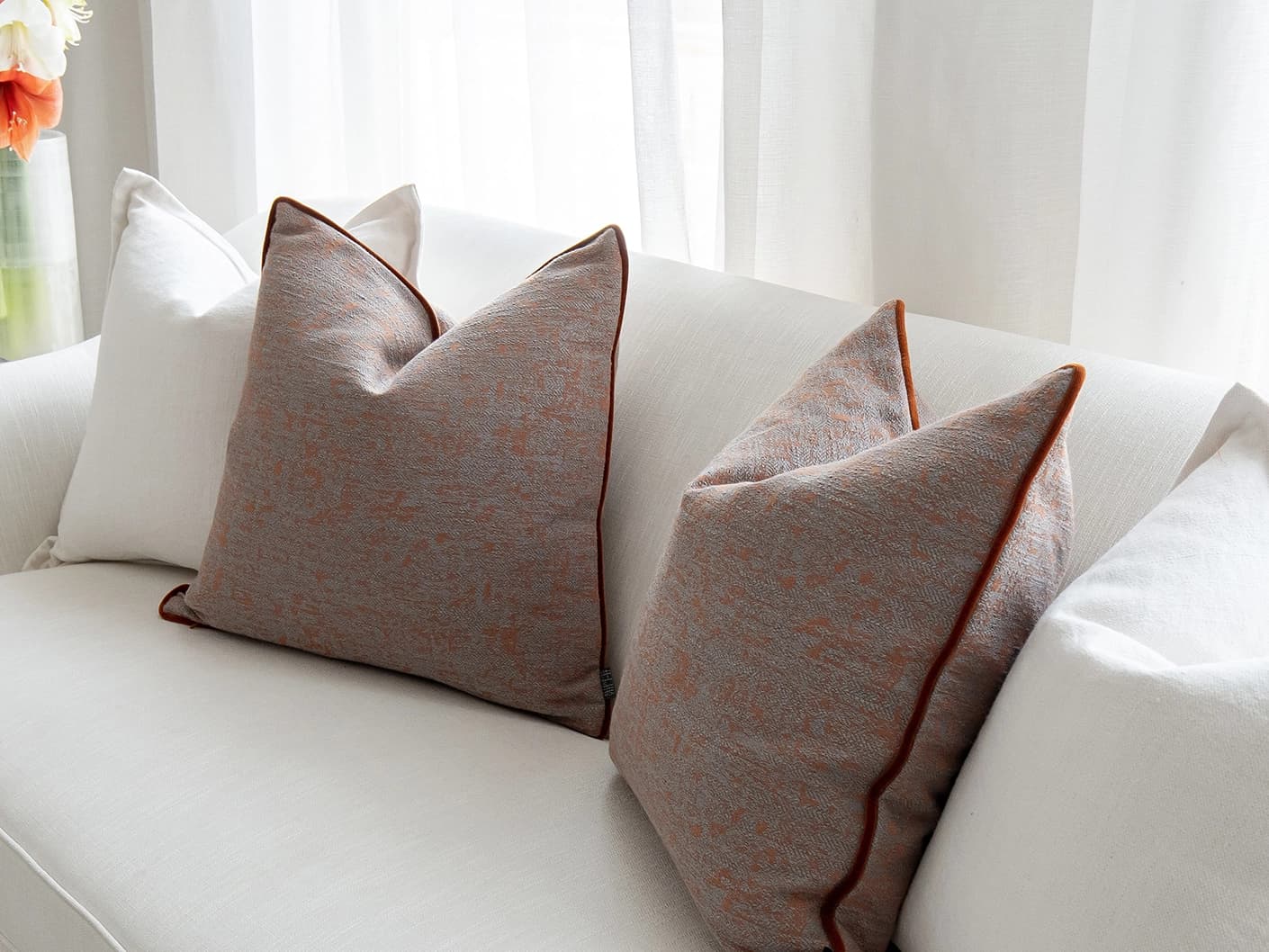 Eloise Bundle bundle cushions in white and orange, shown in a lifestyle front view