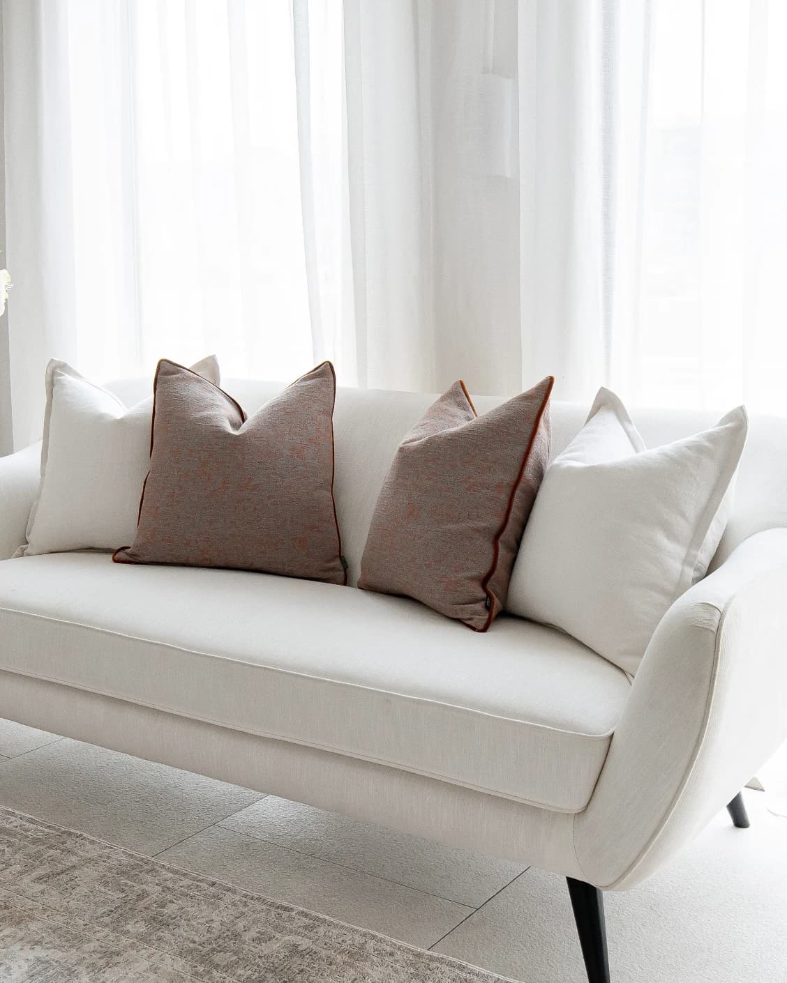Eloise Bundle cushion in white and orange, shown in a lifestyle front view as image 2