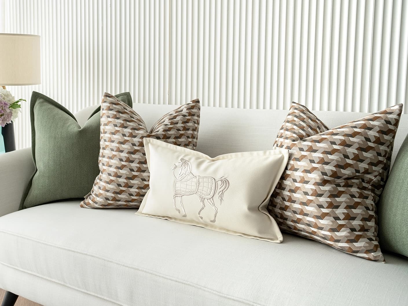 Emmanuela Bundle bundle cushions in orange, beige, white and green, shown in a lifestyle front view