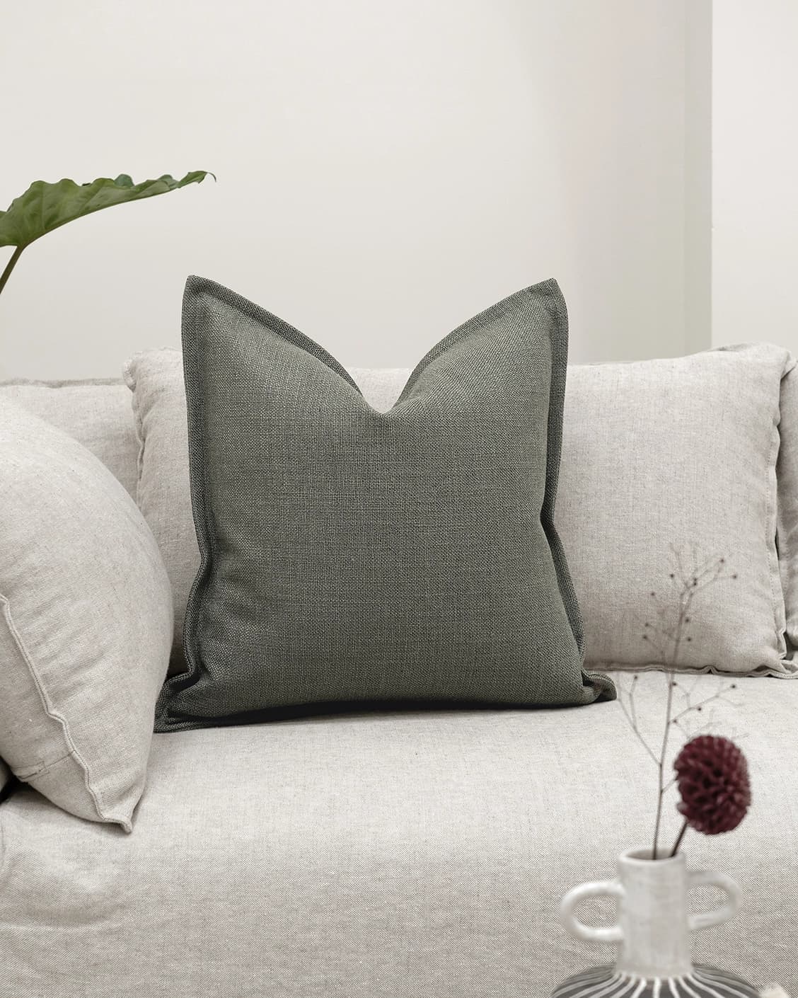 Emmett Olive cushion in green, shown in a lifestyle front view as image 2