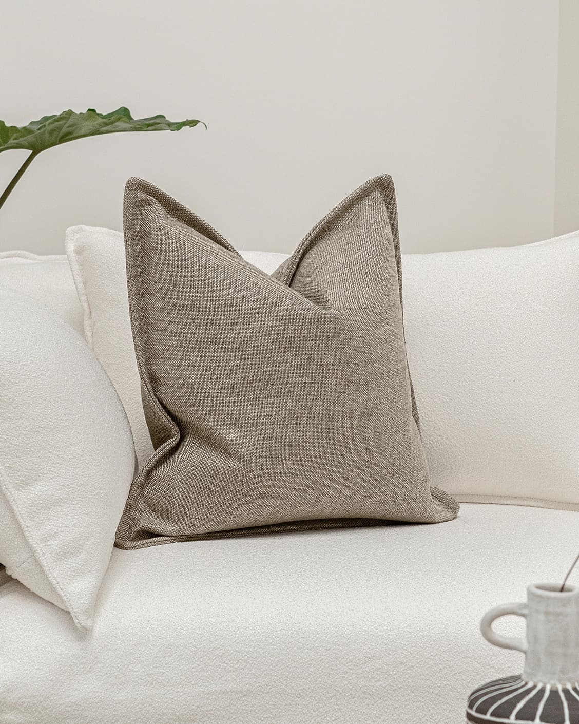 Emmett Quell cushion in taupe and grey, shown in a lifestyle front view as image 2
