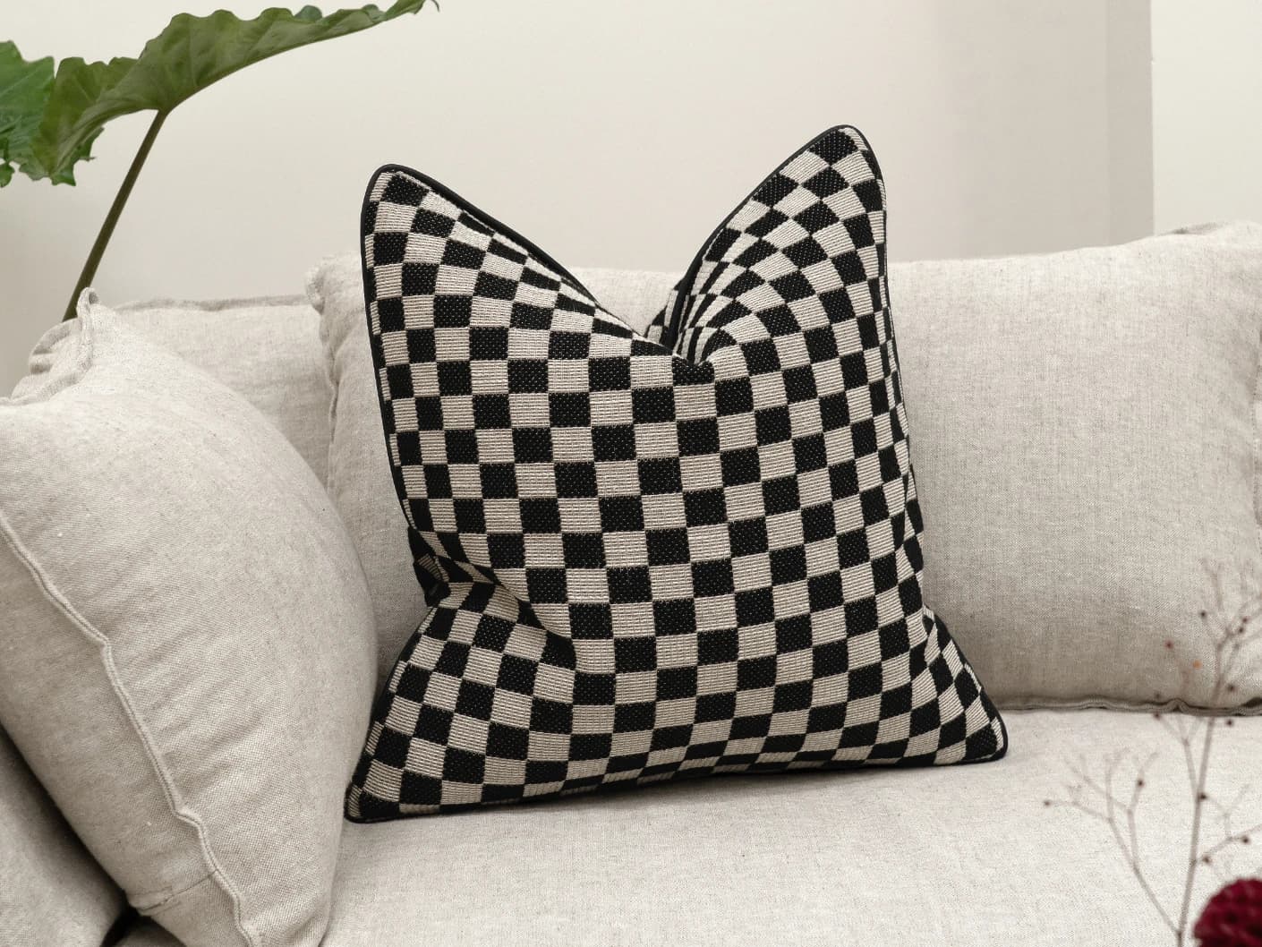 Enya Steele single cushions in black and beige, shown in a lifestyle front view