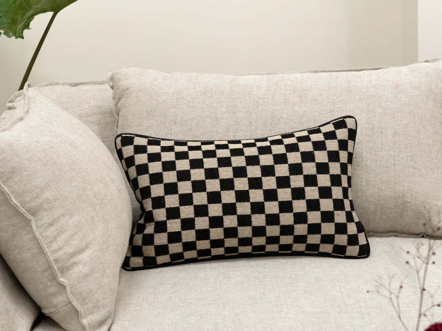 Enya Steele II single cushions in black and beige, shown in a lifestyle front view