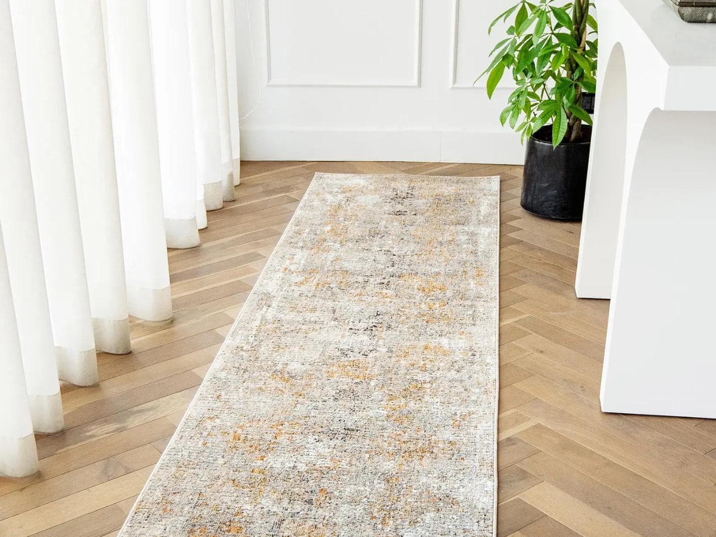Ethan Goldberg carpets in rust, grey and gold, shown in a lifestyle front view as image 1