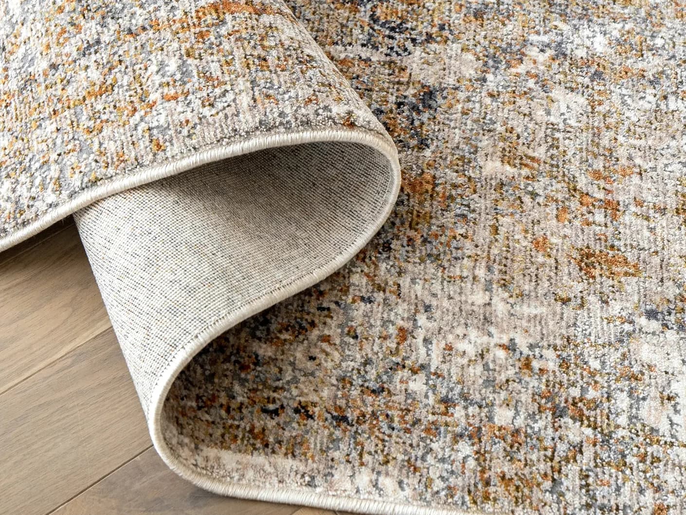 Ethan Goldberg carpets in rust, grey and gold, shown in a product close-up view