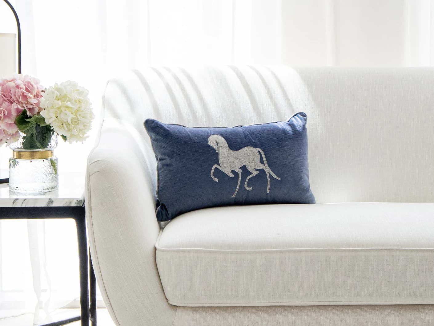 Faaris Matisse single cushions in blue and silver, shown in a lifestyle front view