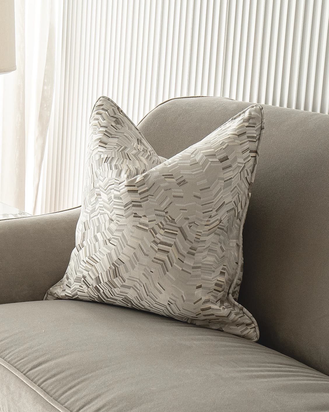 Faye Hodler cushion in silver and grey, shown in a lifestyle front view as image 2