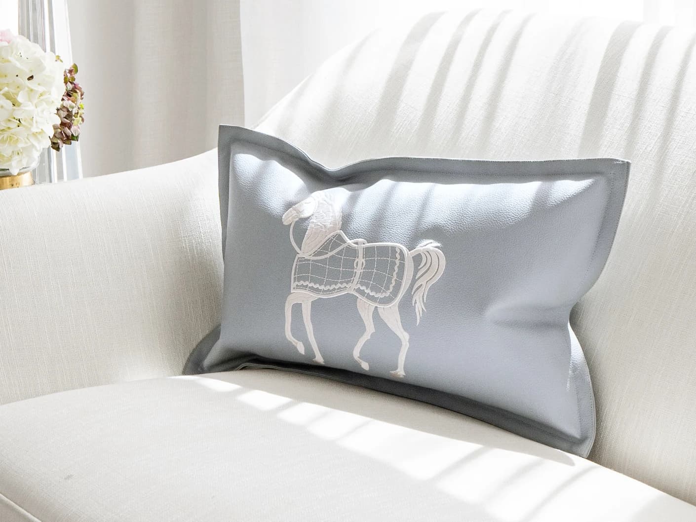 Filip Matisse single cushions in blue and white, shown in a lifestyle front view