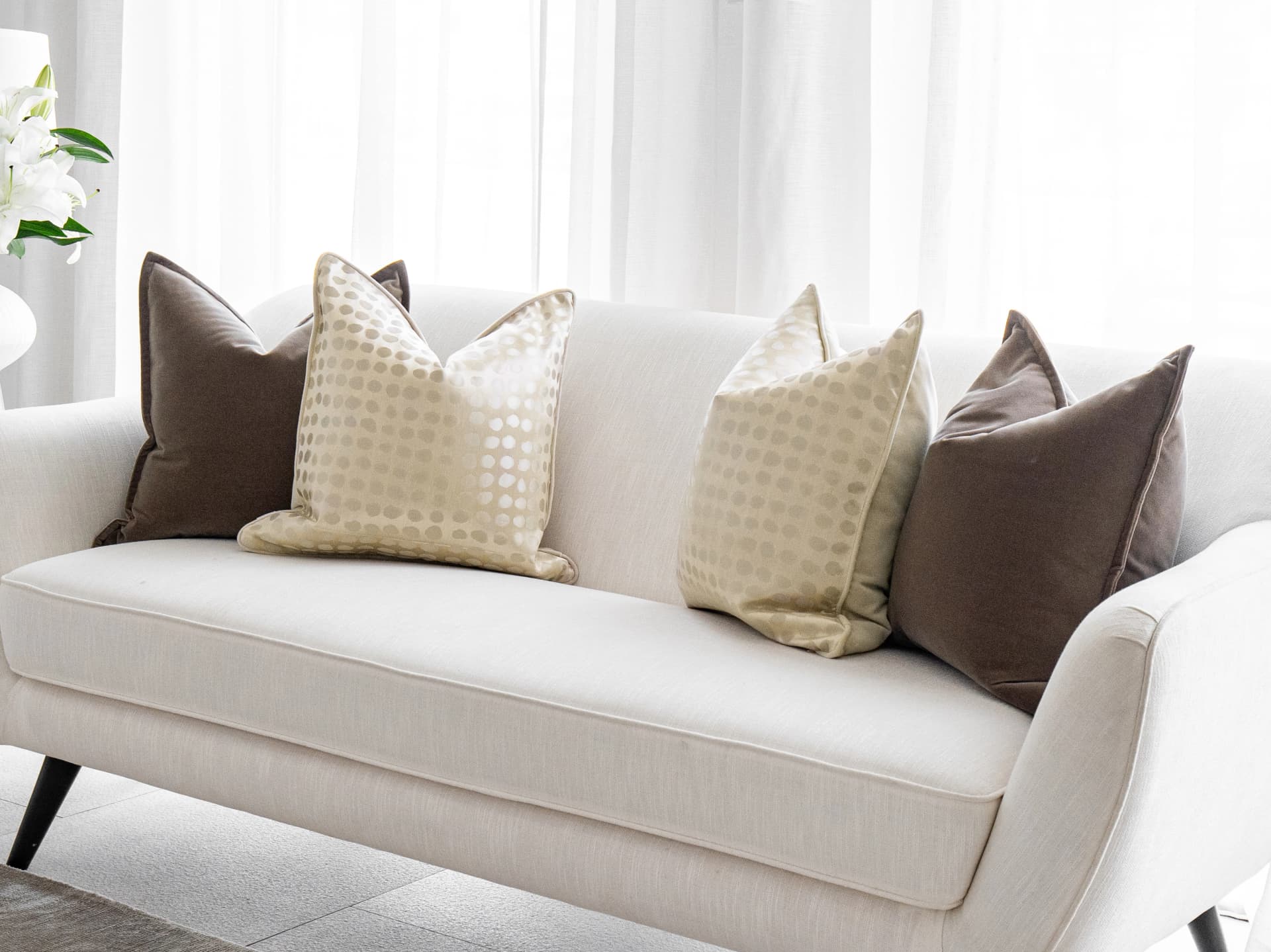 Flora Bundle bundle cushions in brown, beige and gold, shown in a lifestyle front view