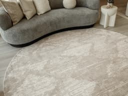 Freida Sandy Round carpet in beige, shown in a lifestyle front view
