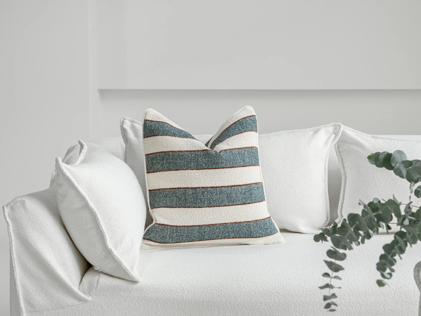 Gia Canova single cushions in blue, shown in a lifestyle front view