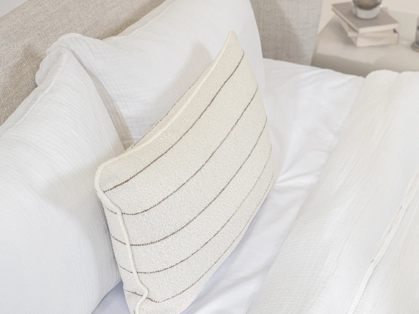 Gia Laurent III single cushions in ivory, shown in a lifestyle left view