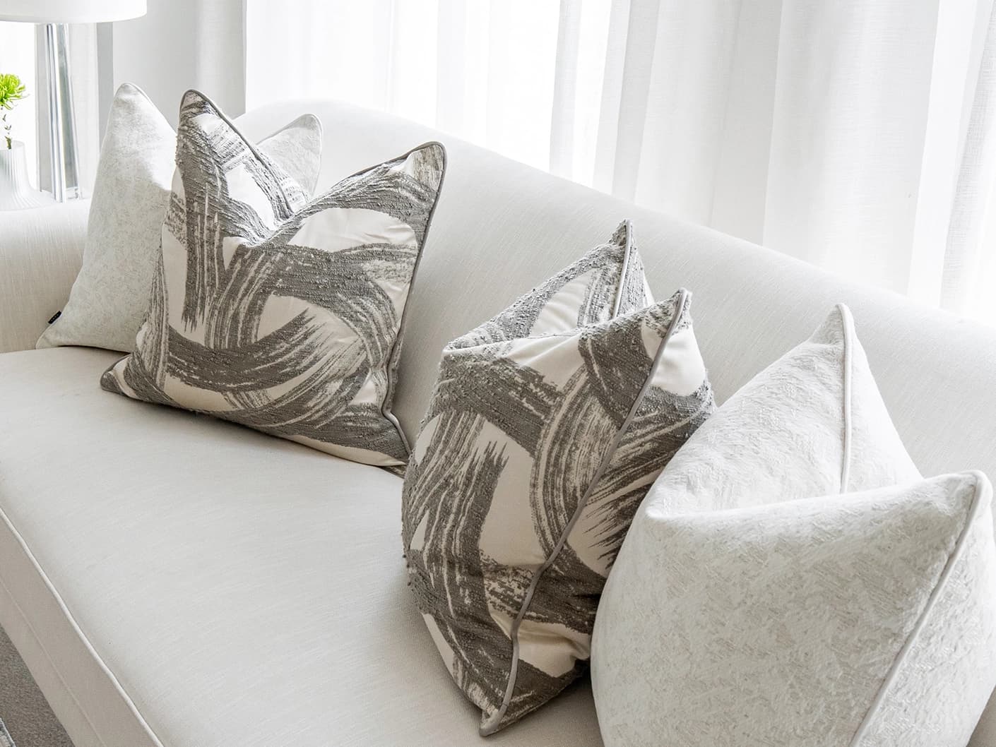 Gianna Bundle bundle cushions in white and grey, shown in a lifestyle front view