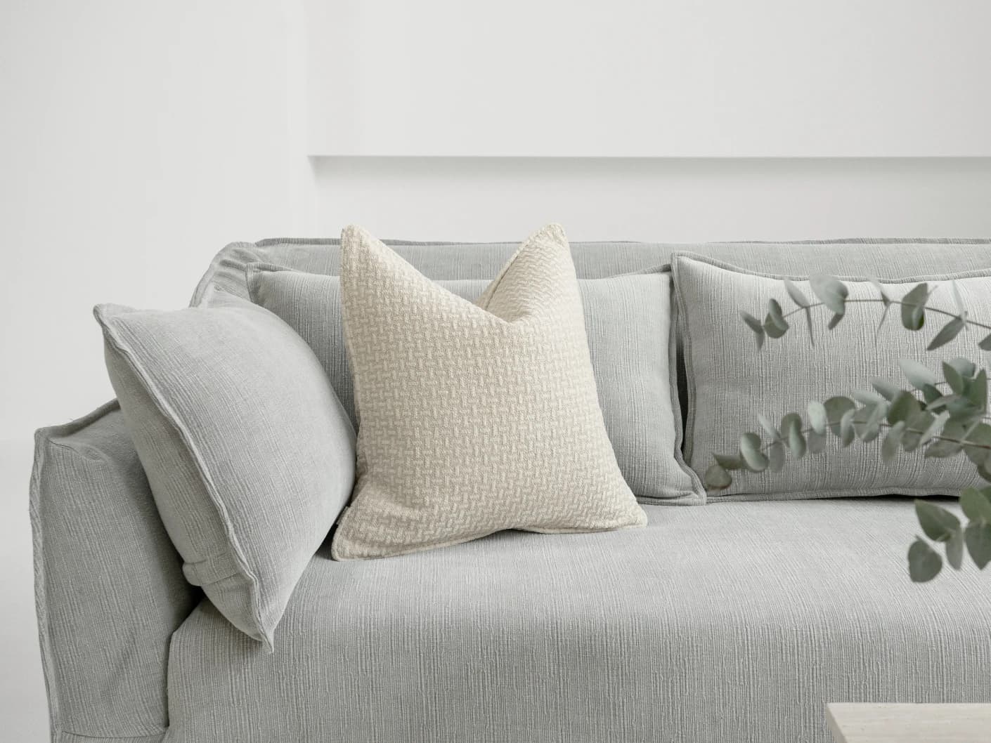 Gigi Laurent single cushions in ivory, shown in a lifestyle front view