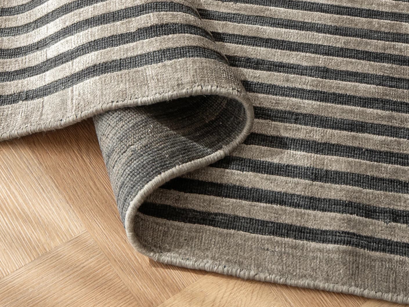 Harf Noon Ebony carpets in ebony and charcoal, shown in a product close-up view