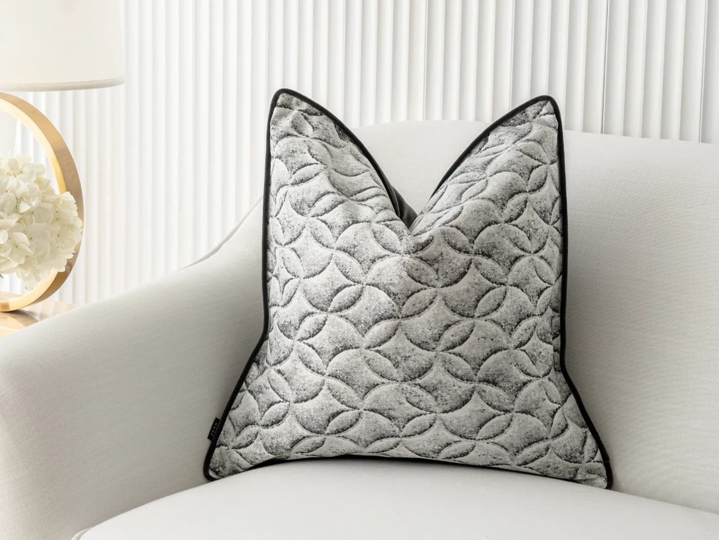 Heera Steele single cushions in white and black, shown in a lifestyle front view