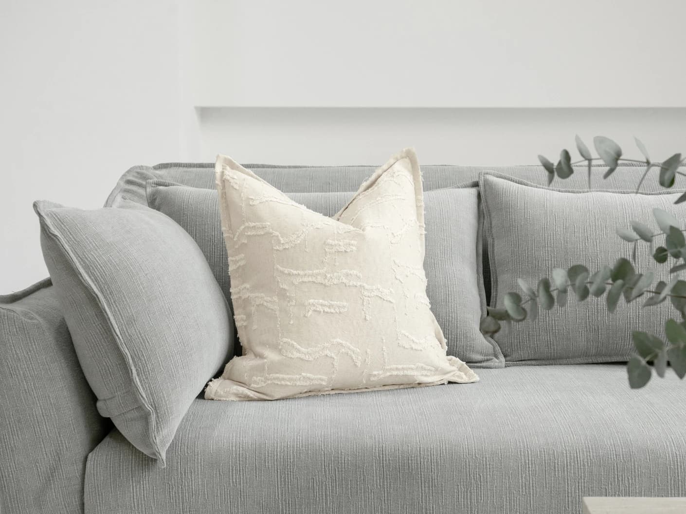 Heeth Laurent single cushions in cream and ivory, shown in a lifestyle front view