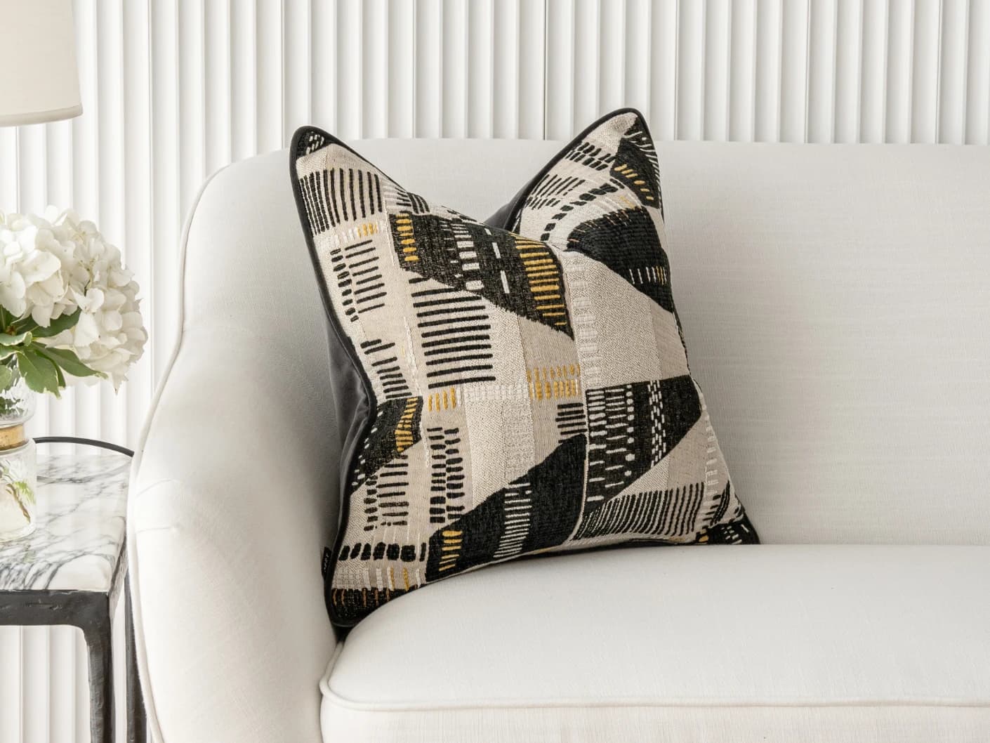 Hilda Steele single cushions in black and beige, shown in a lifestyle front view