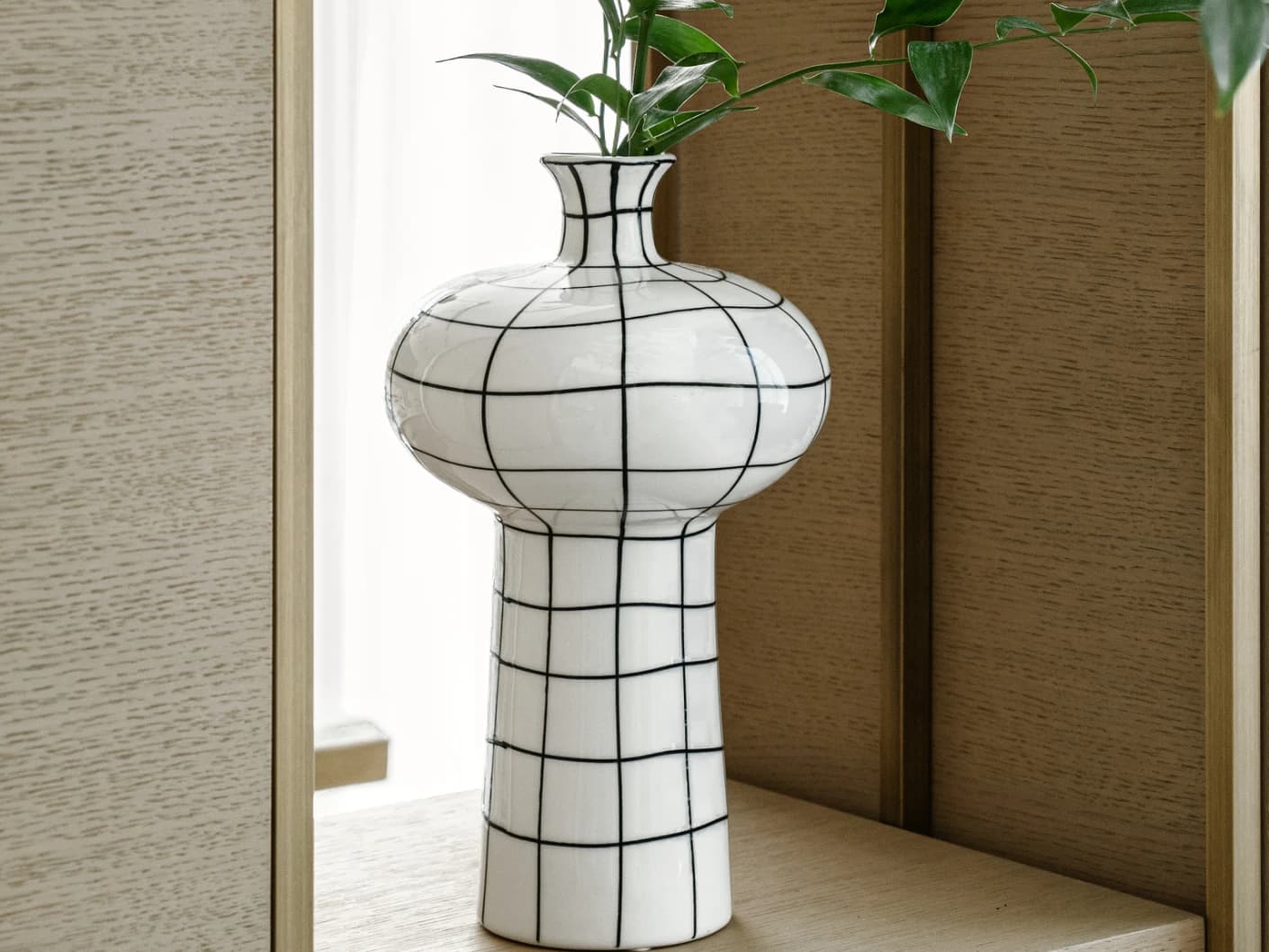 Iris Arneson vases in white and black, shown in a lifestyle left view