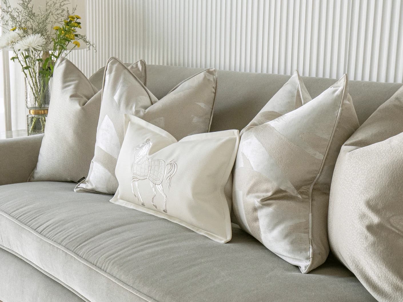 Issa Bundle bundle cushions in gold, beige, silver and white, shown in a lifestyle front view
