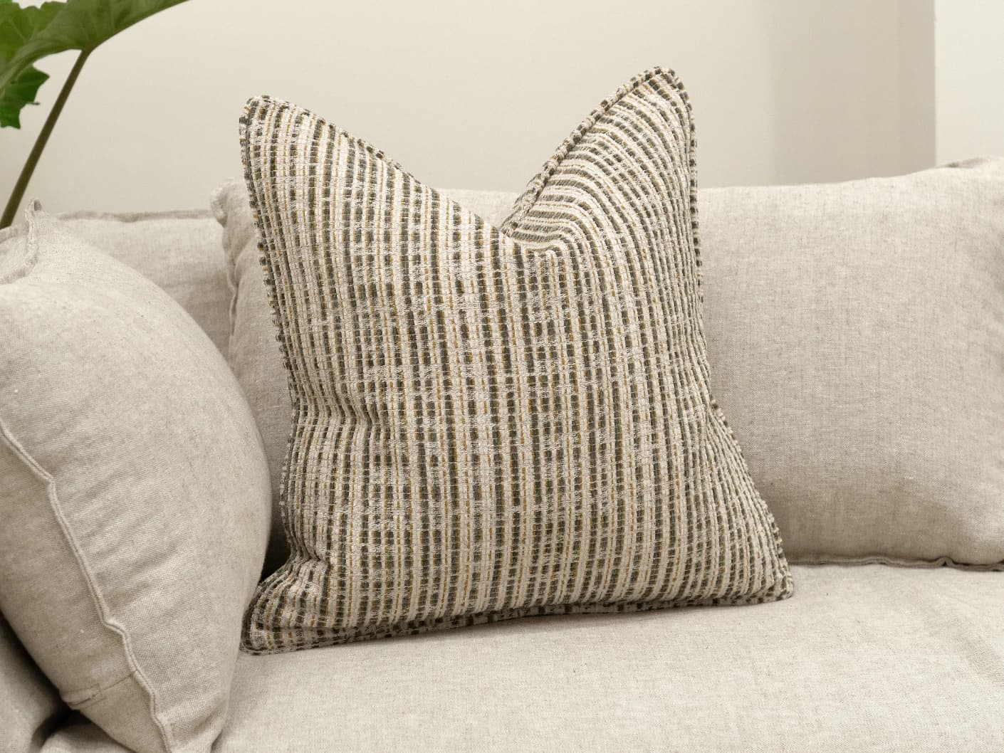 Izzy Olive single cushions in olive and ivory, shown in a lifestyle front view