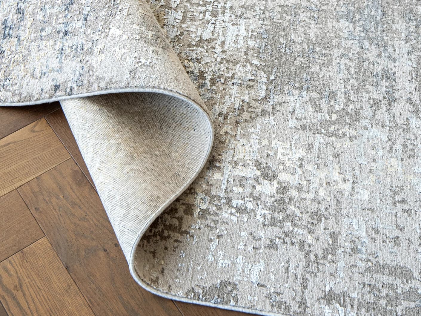 Jacob Ashton Round carpets in grey, silver and white, shown in a product close-up view