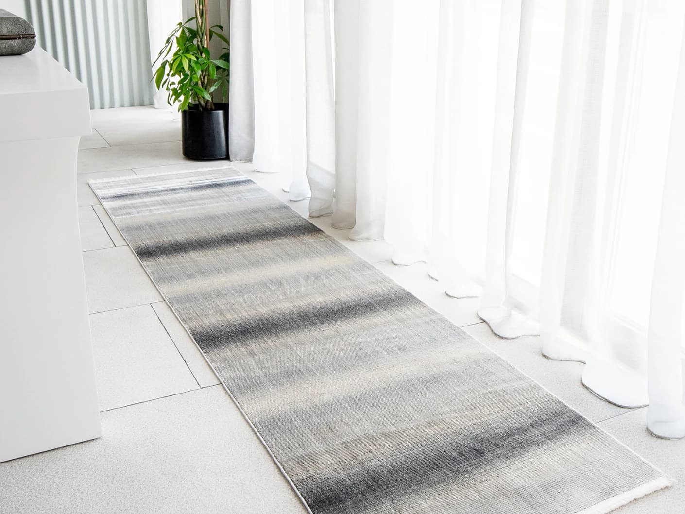 Jade Ashton Runners carpet in grey, shown in a lifestyle left view
