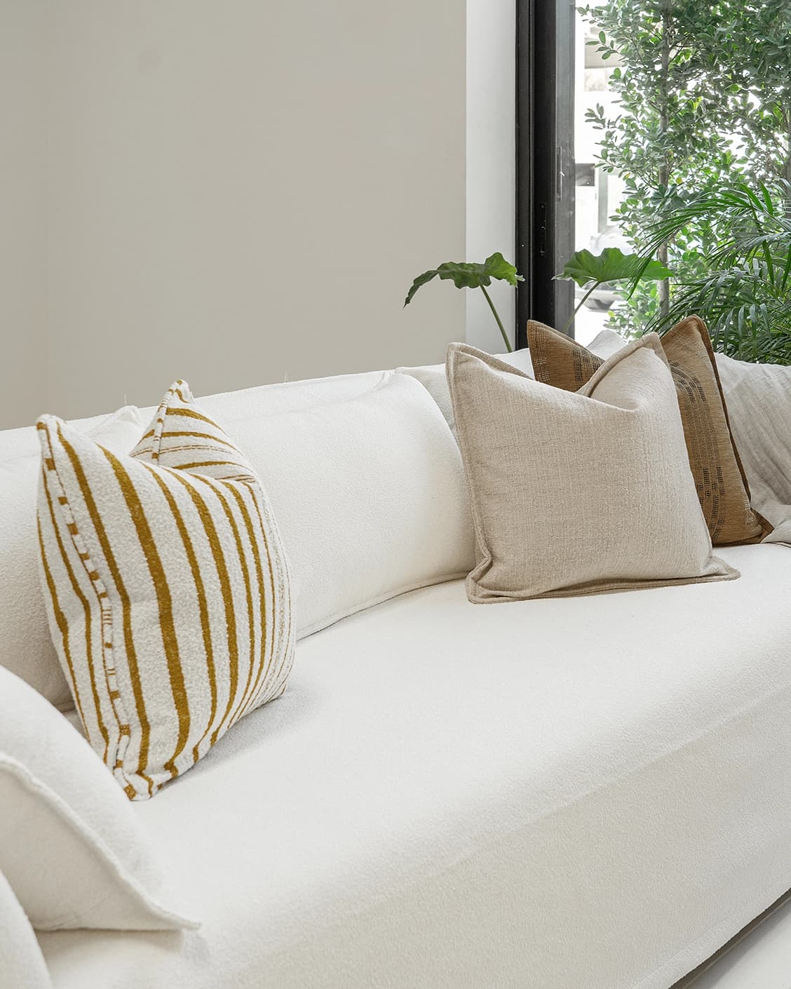 Janina Bundle cushion in beige and cream, shown in a lifestyle left view as image 2