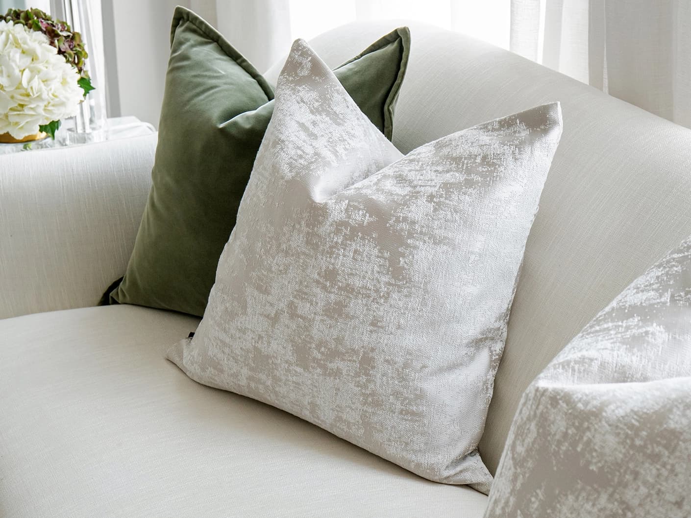 Jayce Bundle bundle cushions in forest green, silver, grey and green, shown in a lifestyle front view