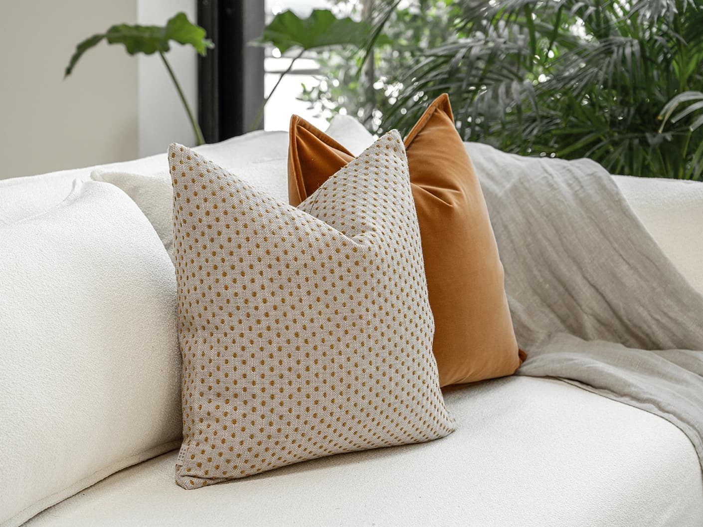 Jolvin Bundle bundle cushions in orange and beige, shown in a lifestyle front view