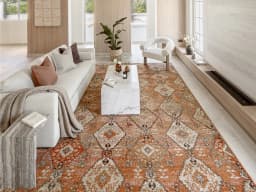 Julian Coral carpet in coral, orange and rust, shown in a lifestyle front view
