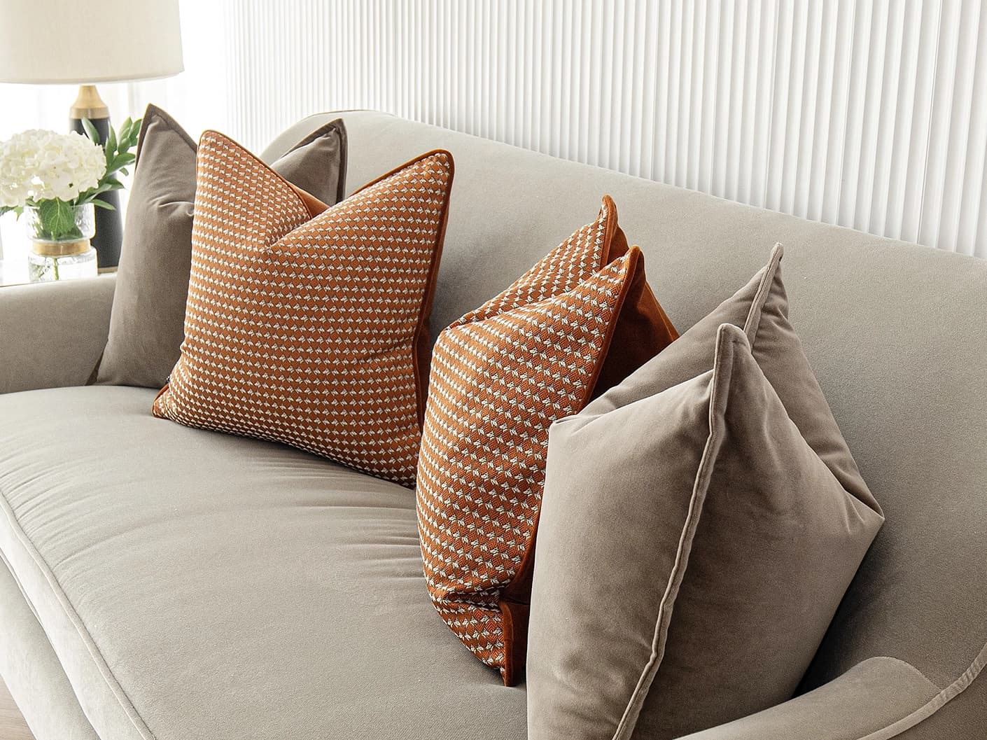 Kalysta Bundle bundle cushions in brown and orange, shown in a lifestyle front view