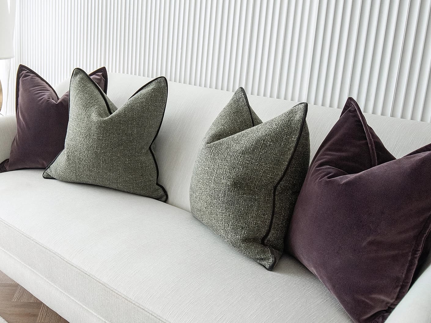 Kamelia Bundle bundle cushions in purple and green, shown in a lifestyle front view