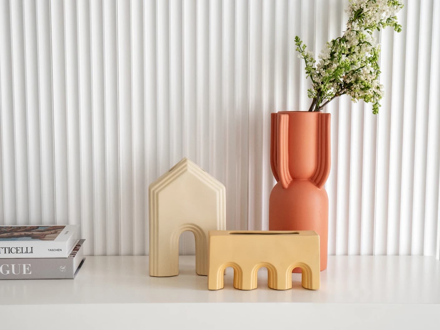 Klara Arneson vases in beige and orange, shown in a lifestyle front view
