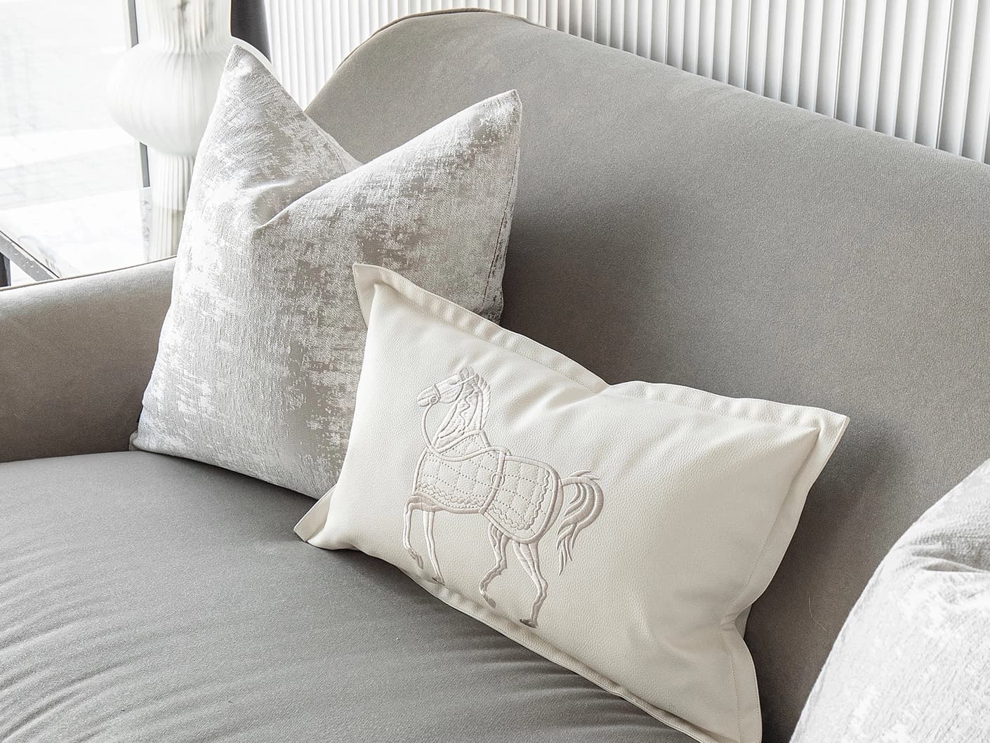 Klaus Bundle bundle cushions in silver, grey and white, shown in a lifestyle front view