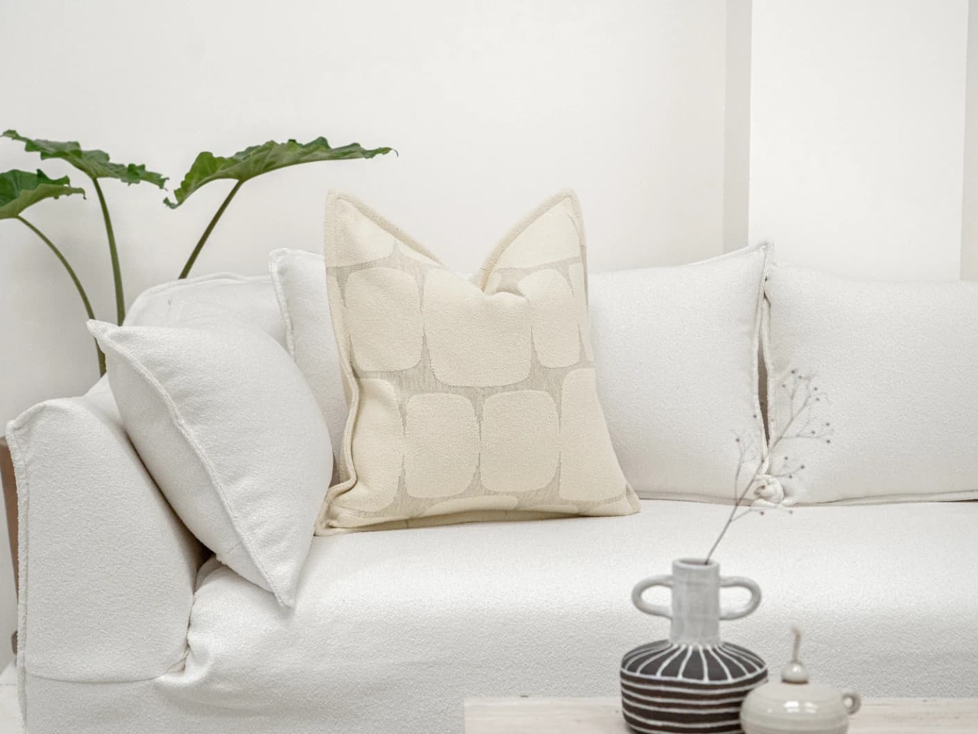 Kyomi Klimt single cushions in ivory and beige, shown in a lifestyle front view