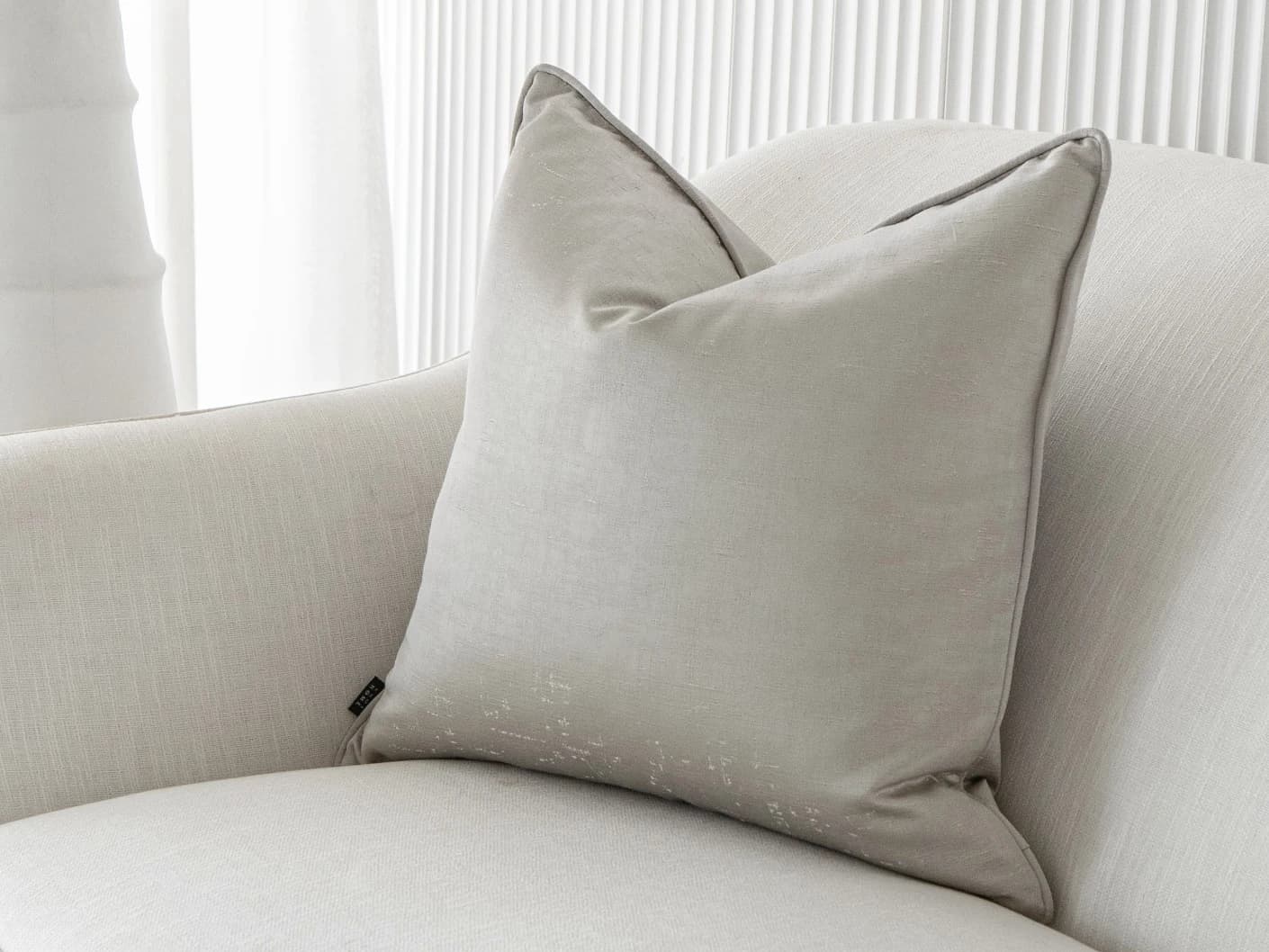 Lainie Laurent single cushions in silver, shown in a lifestyle front view