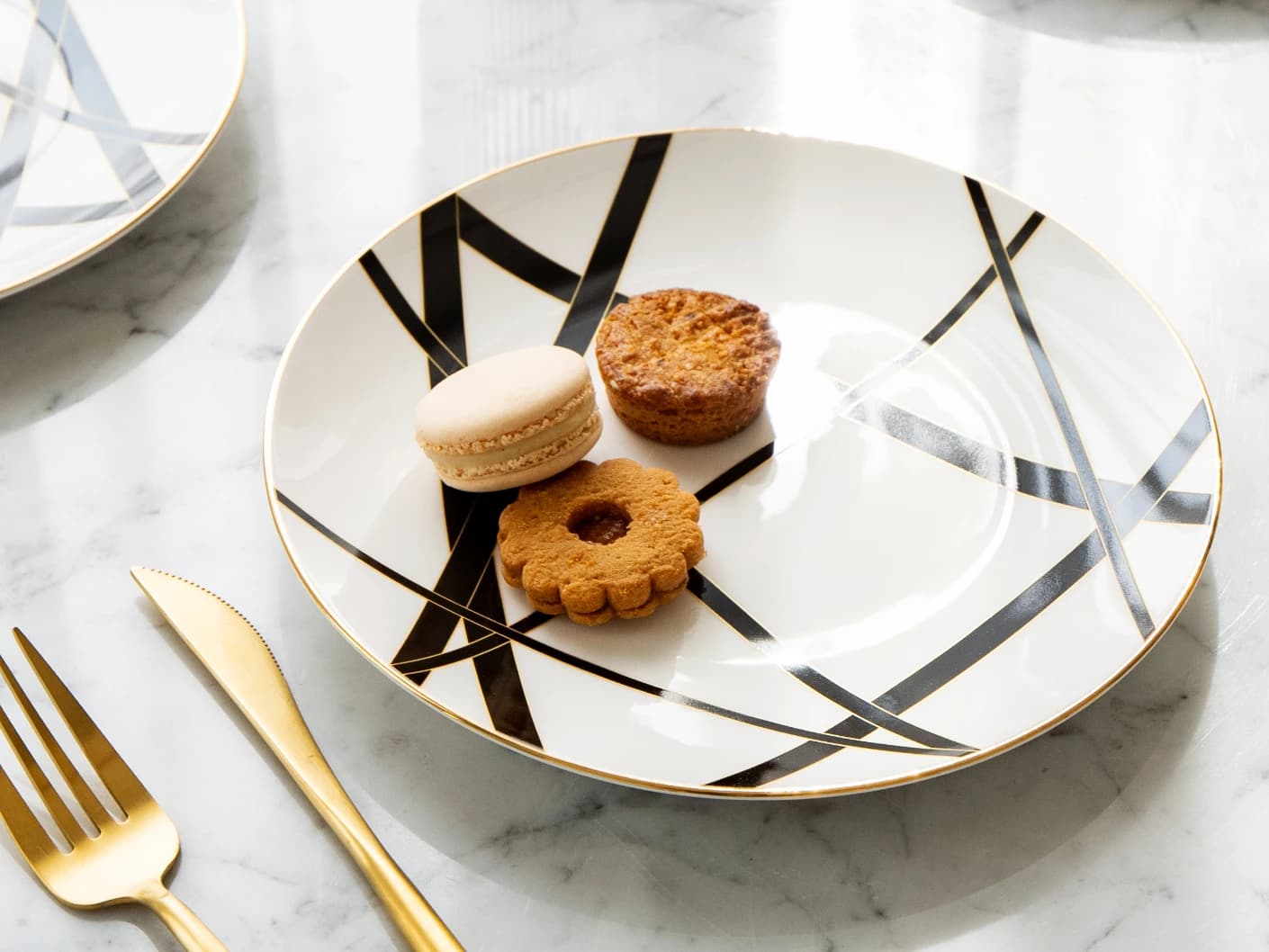 Leanna Viktoria plates in white, black and gold, shown in a lifestyle top view
