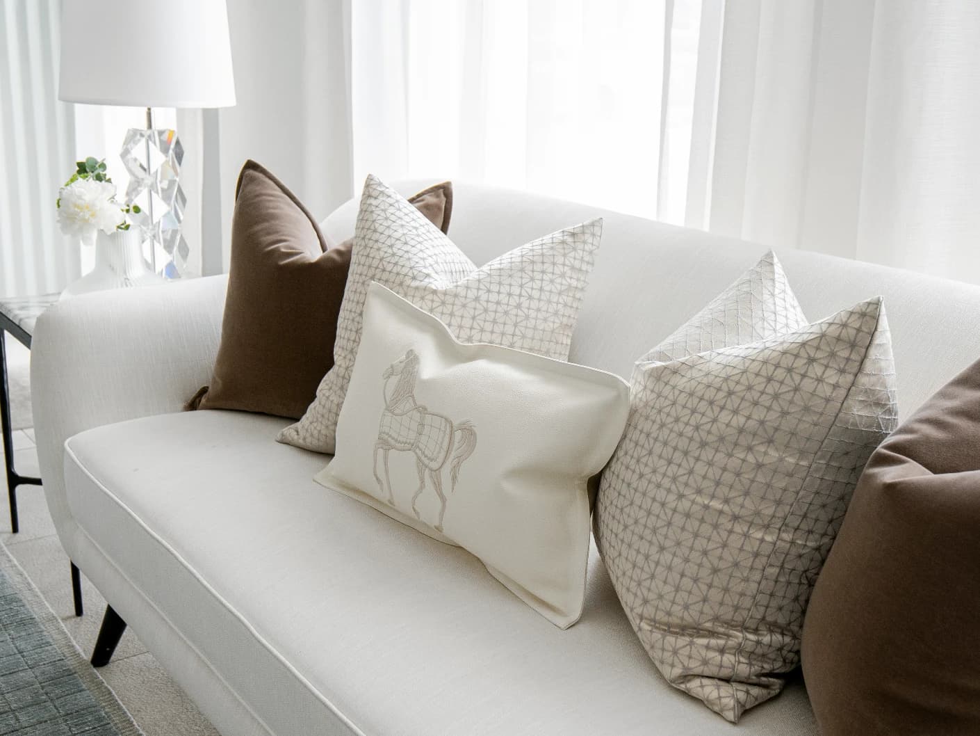 Lina Bundle bundle cushions in brown, silver and white, shown in a lifestyle front view