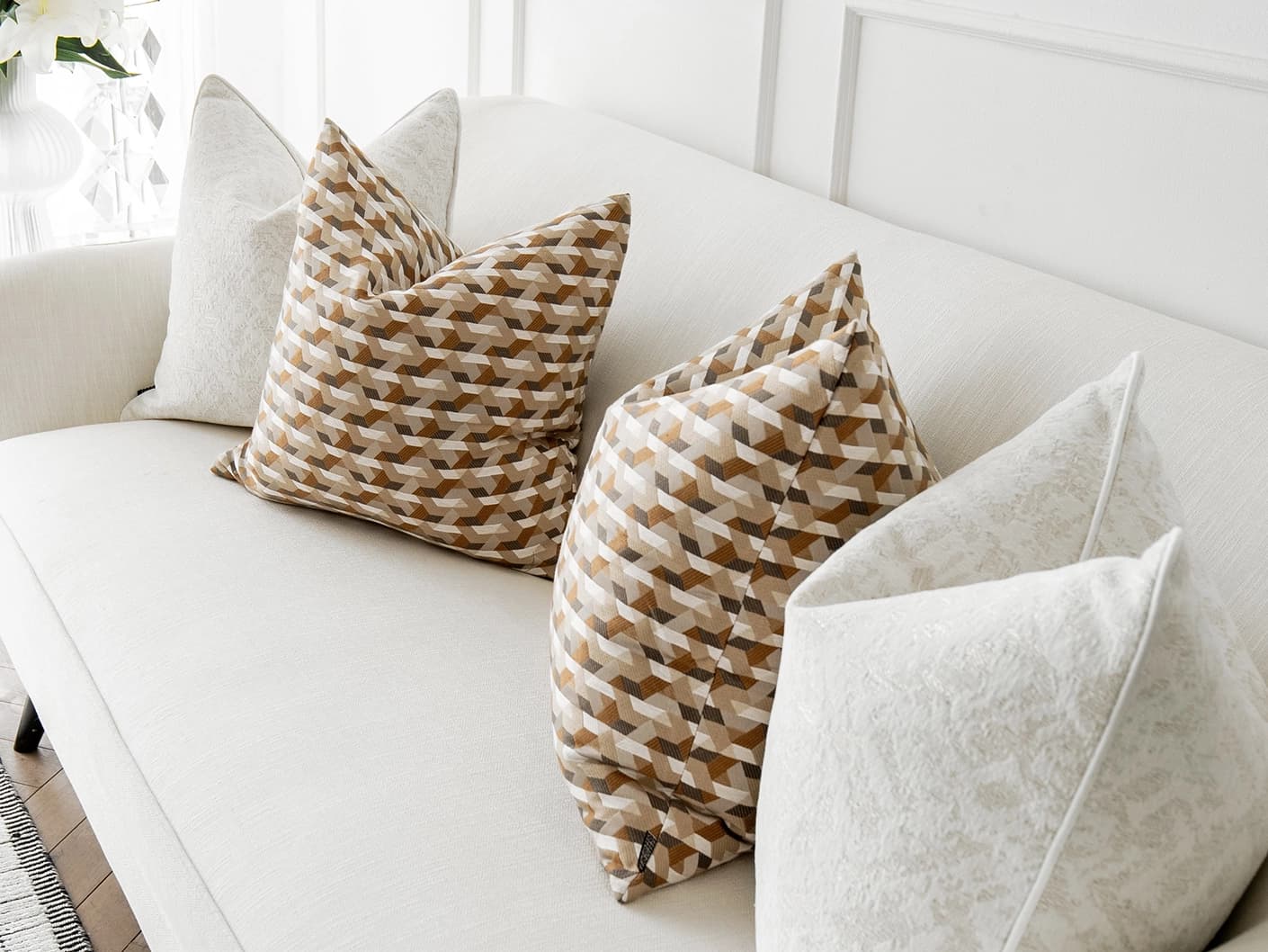 Lorraine Bundle bundle cushions in white, orange and beige, shown in a lifestyle front view