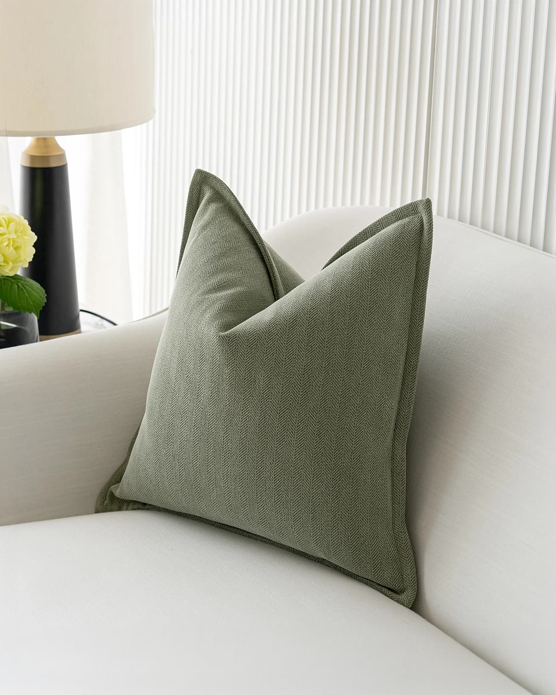 Lyndon Sage cushion in green, shown in a lifestyle front view as image 2